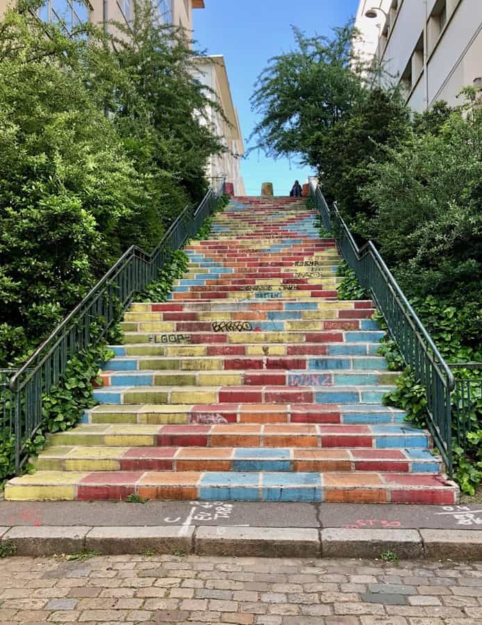 The Escaliers Prunelle are one of the painted staircases in Lyon.  This has a geometric pattern with shades of red, blue, and yellow. It's one of the best Lyon Instagram spots!